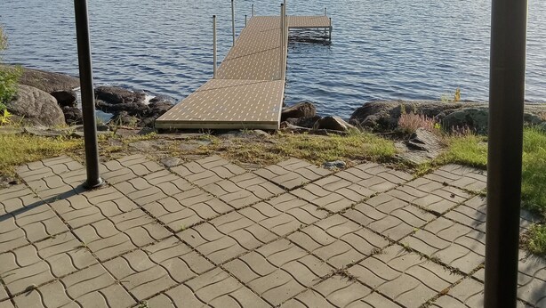 A covered dock extending into a lake with a view of a forested hill in the distance. - Newly Renovated Cabin on a Private Lake Great for a Romantic Getaway or some R&R (Second Eel River Lake)