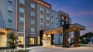 A Hilton Garden Inn building with a modern design, featuring a prominent entrance with a covered walkway and a brick facade. - Hilton Garden Inn Austin Central (Austin)