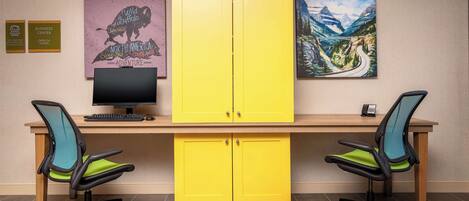 A workspace with two office chairs, a desk, a computer, and two yellow cabinets.