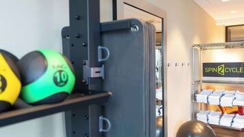 Un gimnasio con equipo de ejercicios, incluyendo un banco de mancuernas y una bicicleta estática.