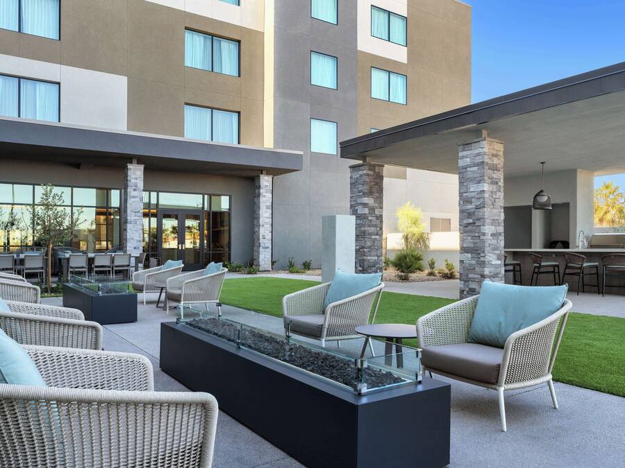 An outdoor seating area with wicker furniture and a fire feature.