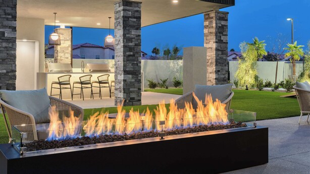 An outdoor patio with a fire feature, stone pillars, and a seating area with chairs and a table. - Homewood Suites By Hilton North Las Vegas Speedway (North Las Vegas)