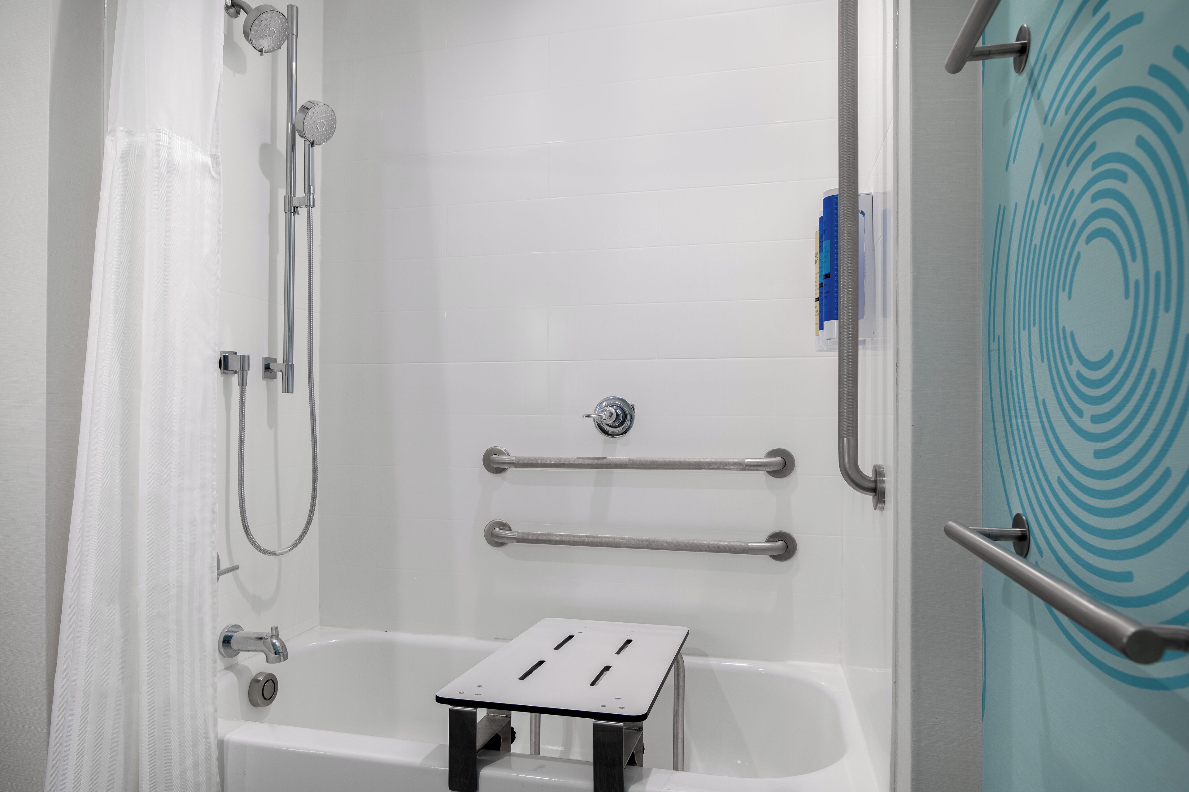 A modern bathroom with a shower, grab bars, and a bathtub.