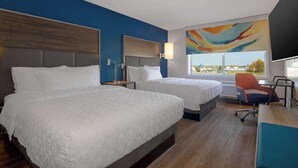 A hotel room with two beds, a desk, a chair, a lamp, and a large window with a view. - Tru By Hilton Anderson (Anderson)