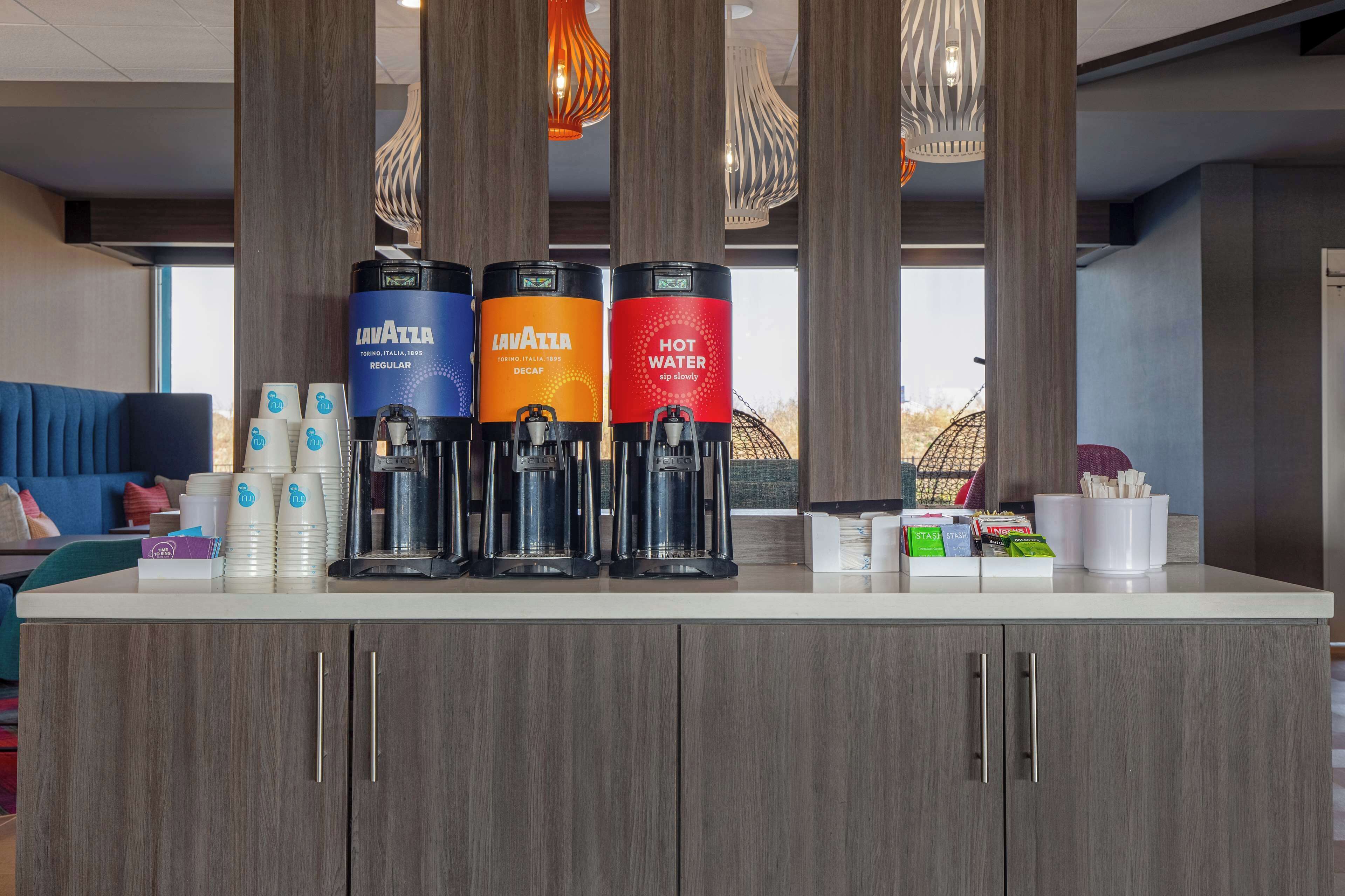 A coffee station with three dispensers labeled 'Lavazza' and 'Hot Water'.