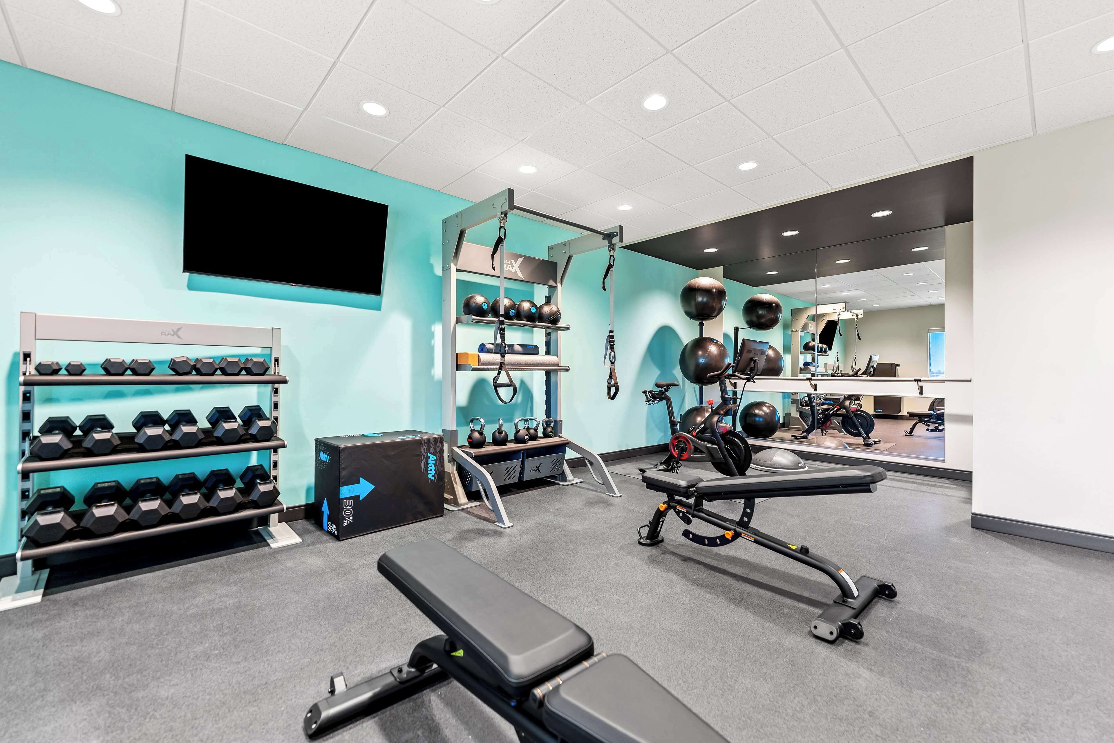 A gym with weight racks, exercise balls, and a stationary bike.