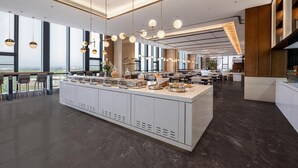 A modern hotel lobby with a central island, large windows, and contemporary lighting fixtures. - Hilton Garden Inn Fenyang Yulongwan (Lvliang)