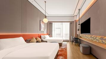 Une chambre d’hôtel moderne, dotée d’un grand lit, d’un bureau, d’une télévision et offrant une vue sur la ville.