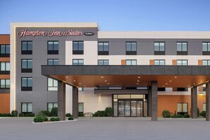 A modern hotel entrance with a prominent sign for Hampton Inn & Suites by Hilton. - Hampton Inn & Suites Orangeville, On (Mono)