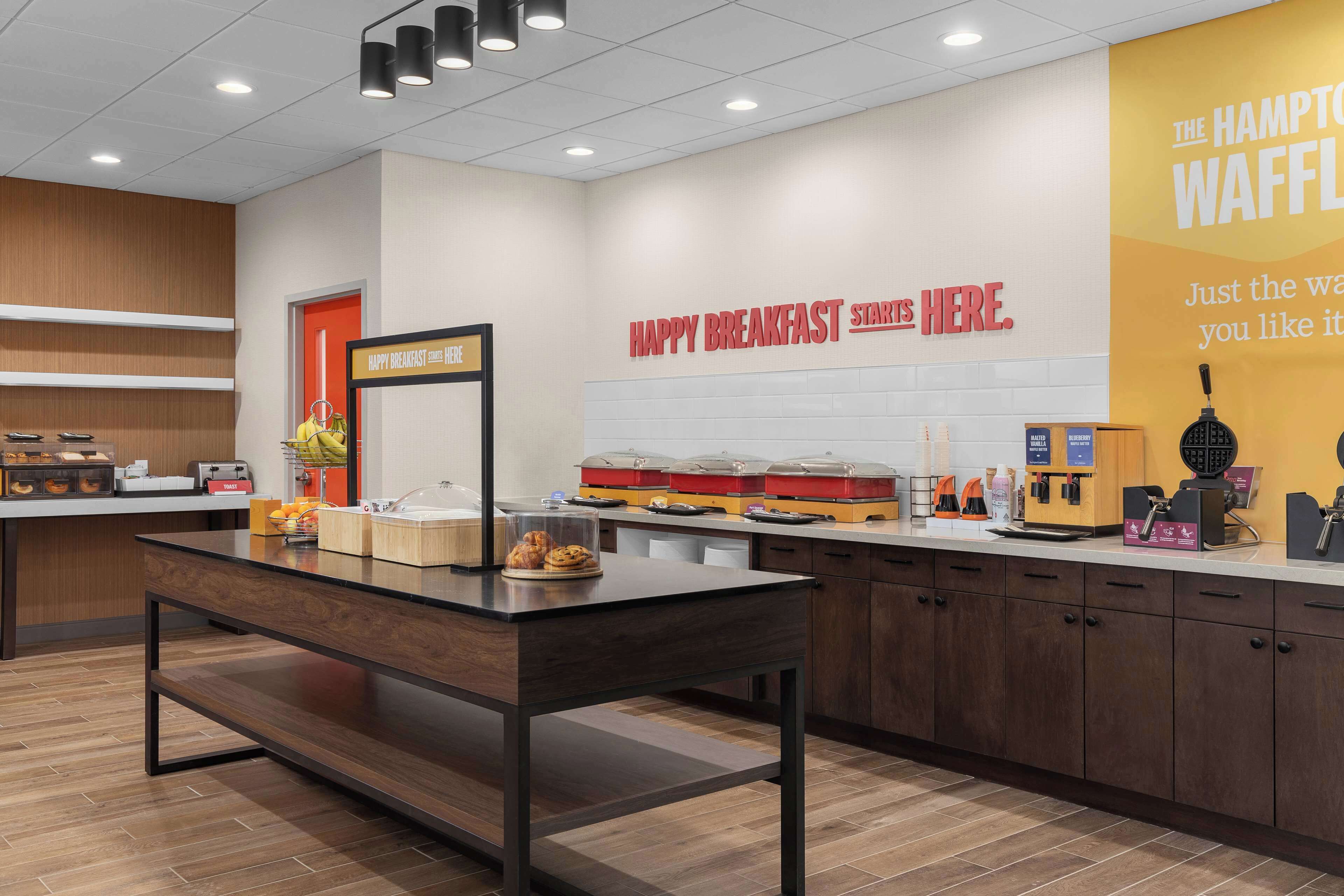 Un área de desayuno con un letrero que dice 'HAPPY BREAKFAST STARTS HERE'.