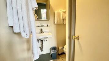 Un baño con inodoro, lavabo y barra para toallas.