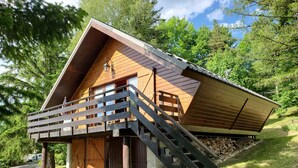 A wooden cabin with a balcony, a staircase leading to the entrance, and a covered porch area. - Chalet in the mountains, Massif du Vercors, 1100 meters, Piano at your disposal (Lans-en-Vercors)