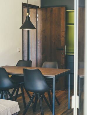 A modern dining area with a wooden table and black chairs.
