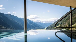 A serene lake with mountains in the background, viewed from a balcony with a glass floor. - Superb 1-Bedroom Penthouse with a View of the Dolomites (Large) (Trentino-Alto Adige)