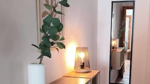 A hallway with a wooden console table, a potted plant, a framed picture, and a mirror. - Charming house just two minutes from the historic center of Ayamonte. (Ayamonte)