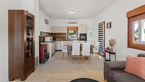 A compact living space with a kitchenette, dining area, and a sofa.