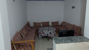 Una habitación con un sofá, una mesita y un televisor.