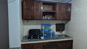 Una cocina compacta con muebles de madera, una estufa a gas y un lavamanos.