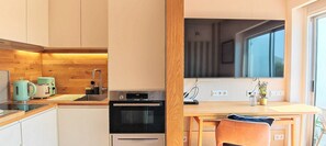 A compact kitchen with a Bosch oven, a sink, and a wooden countertop.