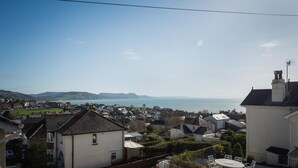 A coastal residential area with houses, a clear sky, and a view of the sea. - Host Stay Ammonite (Lyme Regis)