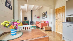 Una sala acogedora con una mesa de madera, un sofá y un mueble de madera.