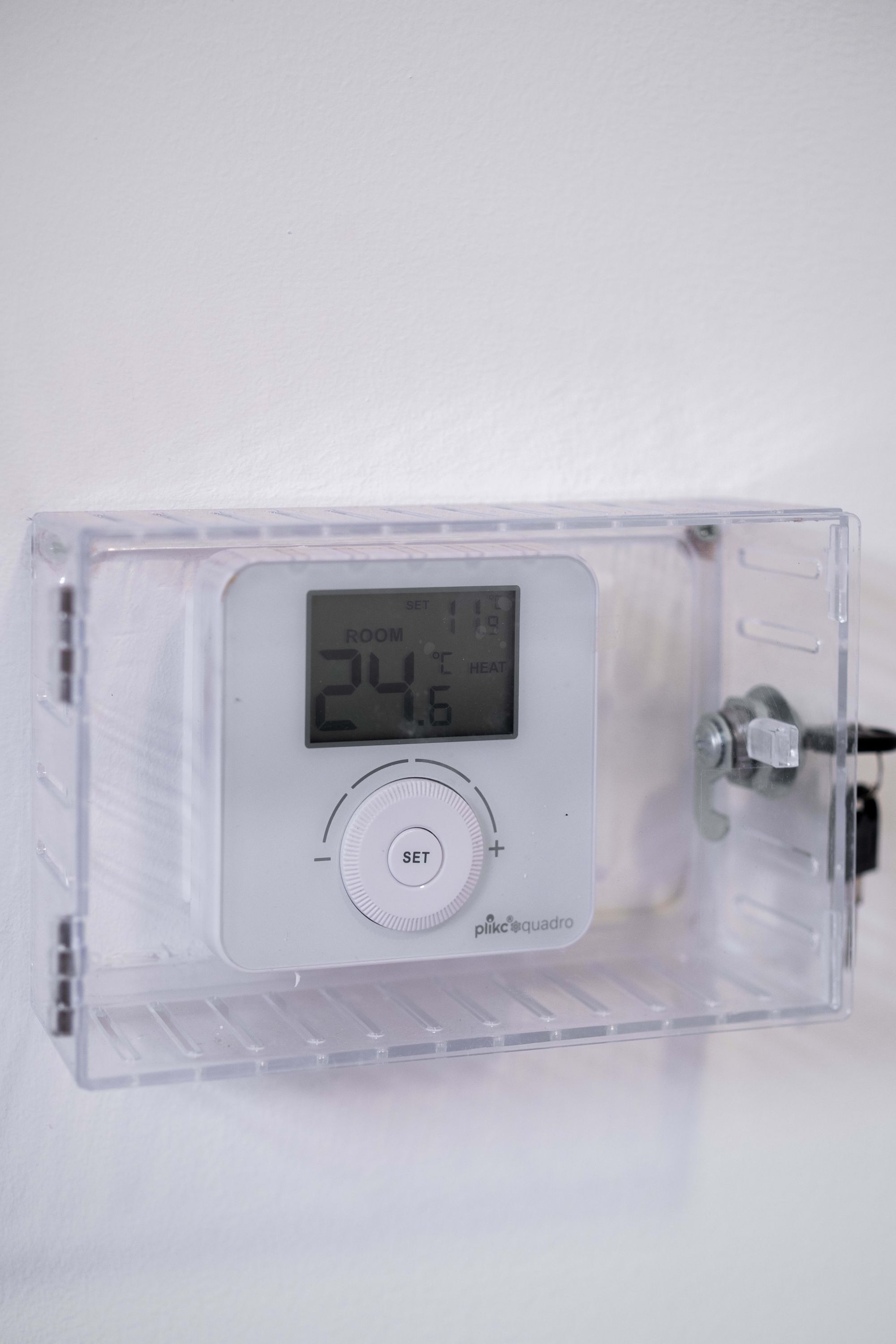 A digital thermostat with a display showing 24.6 degrees Celsius.