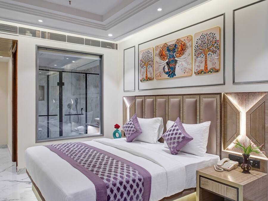 A modern bedroom with a large bed, a ceiling fan, and artwork on the wall.