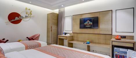 Habitación de hotel con dos camas, televisión, escritorio, minibar y armario.