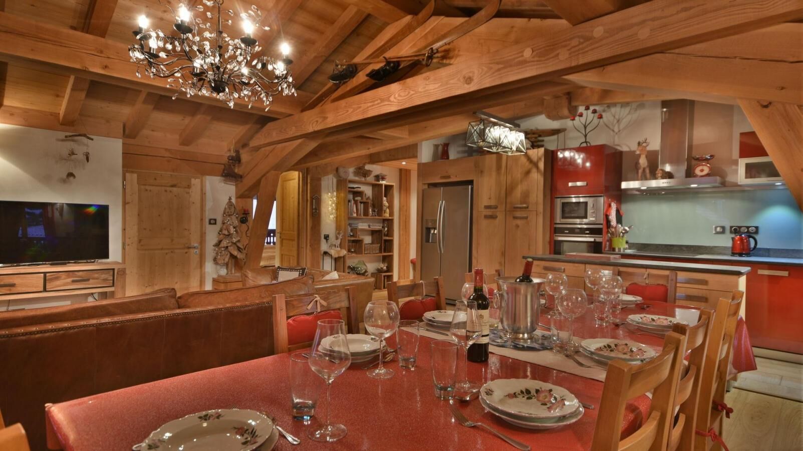 A dining area with a wooden table set for a meal, surrounded by wooden chairs.