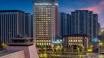 A hotel named "DOUBLETREE by Hilton" with a modern design, surrounded by other high-rise buildings.