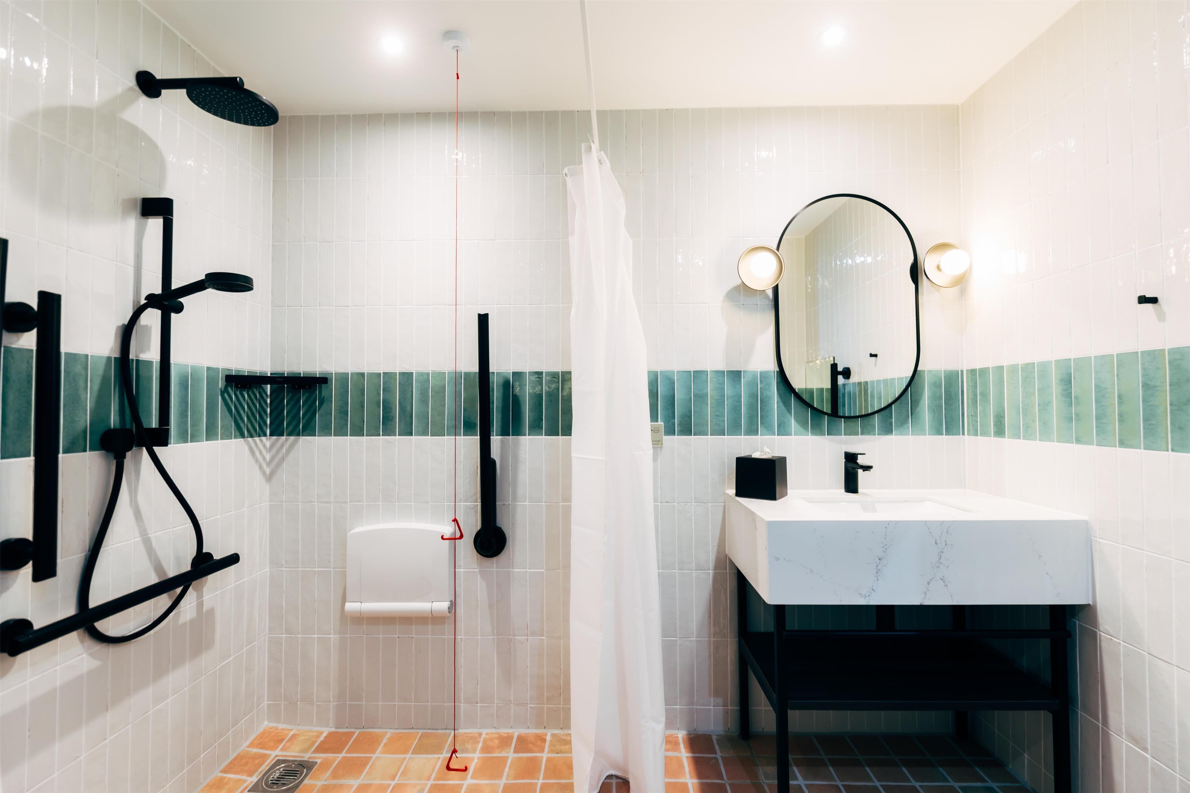 A modern bathroom with a shower, a sink, a toilet, and a mirror.