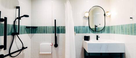 A modern bathroom with a shower, a sink, a toilet, and a mirror.