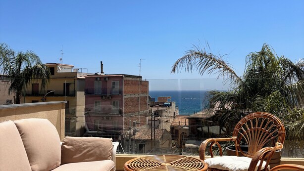 A balcony with wicker furniture and a view of the sea. - IG - Villa Don Antonio  Apartment  (Giardini Naxos)