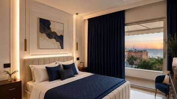 Um quarto moderno com uma cama grande, uma mesa de cabeceira, um quadro na parede e vista para o mar através de uma janela.