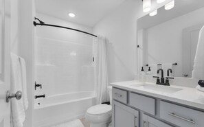 Ein modernes Badezimmer mit Badewanne, Toilette und Waschtisch mit Spiegel.