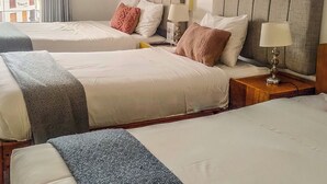 A hotel room with two beds, a window with curtains, a lamp on the nightstand, and a view of buildings outside. - Central Market Hotel San Pedro (Cusco)