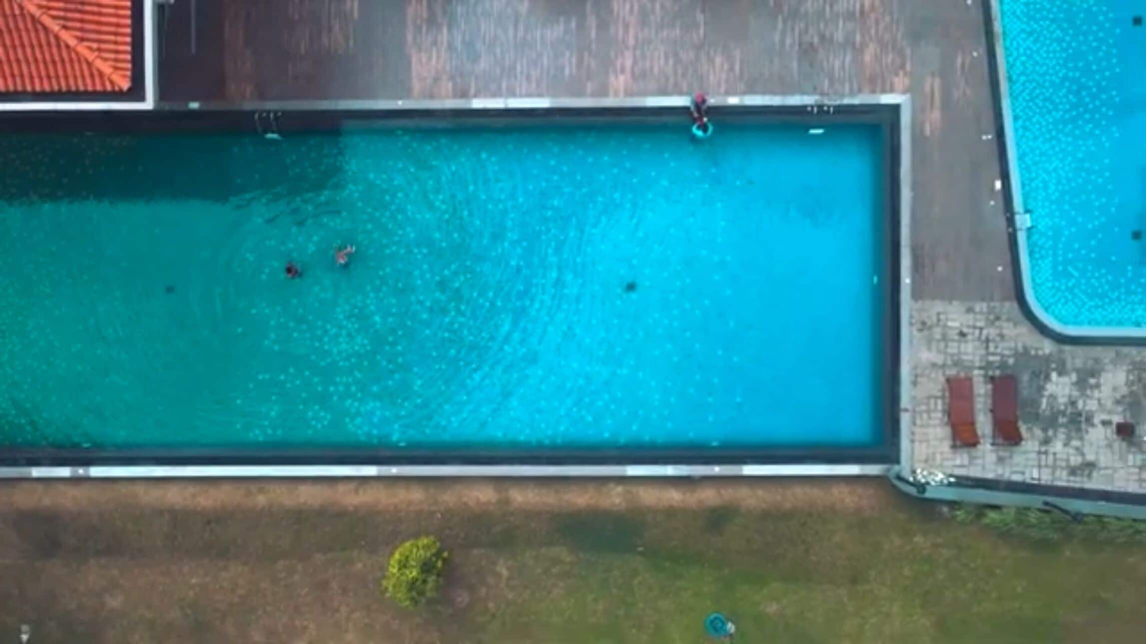 Vista aérea de una piscina rectangular con un borde de baldosas.