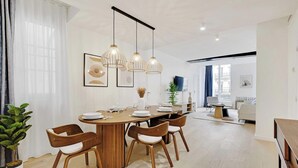 Un'area pranzo moderna con un tavolo in legno, sei sedie e illuminazione a sospensione.