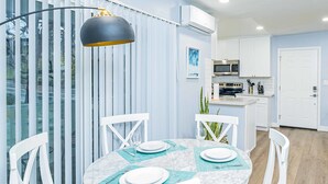 Une cuisine moderne avec des meubles blancs, un four à micro-ondes et une cuisinière.