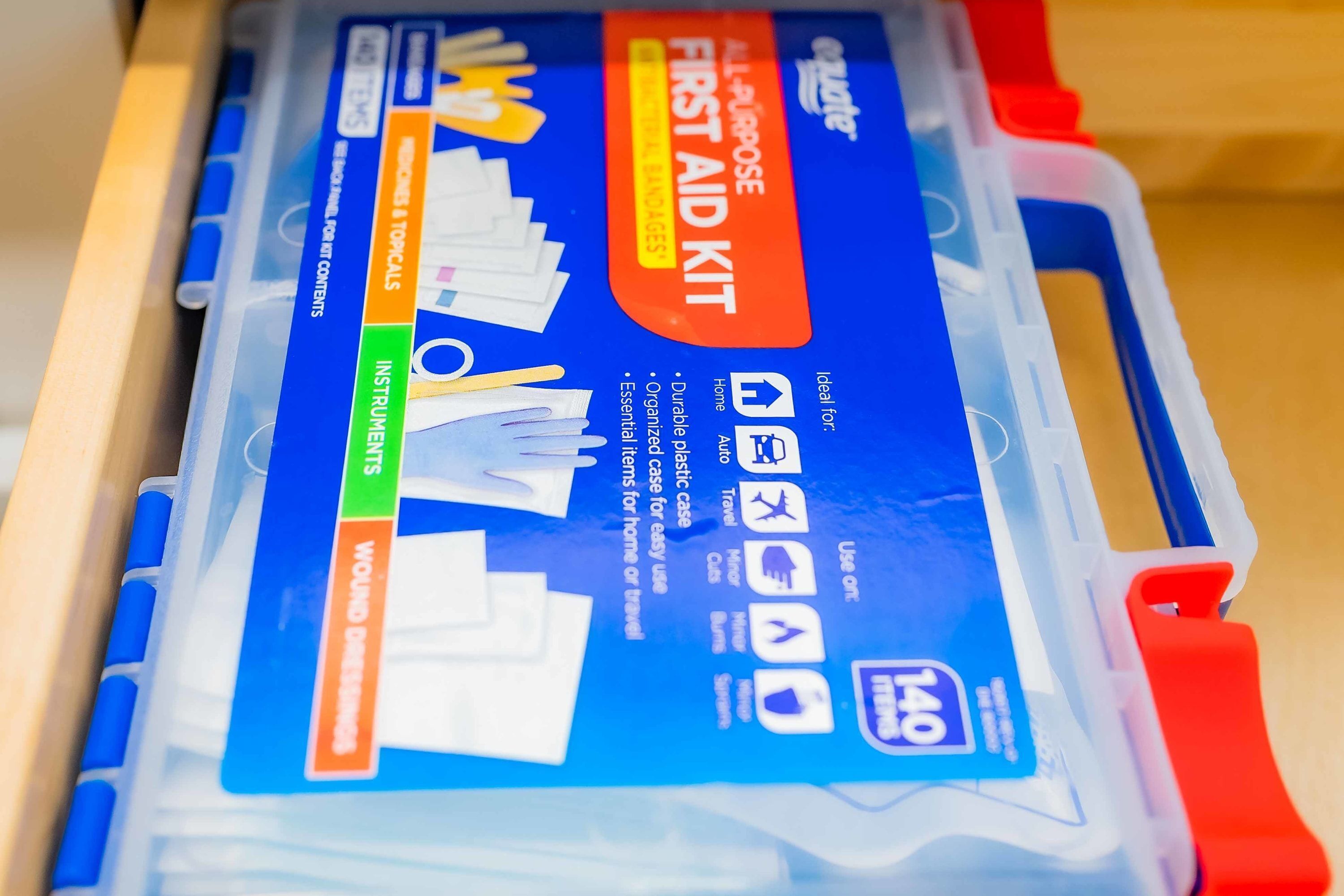 Botiquín de primeros auxilios en un estuche de plástico con compartimentos identificados para instrumentos, heridas y otras categorías.