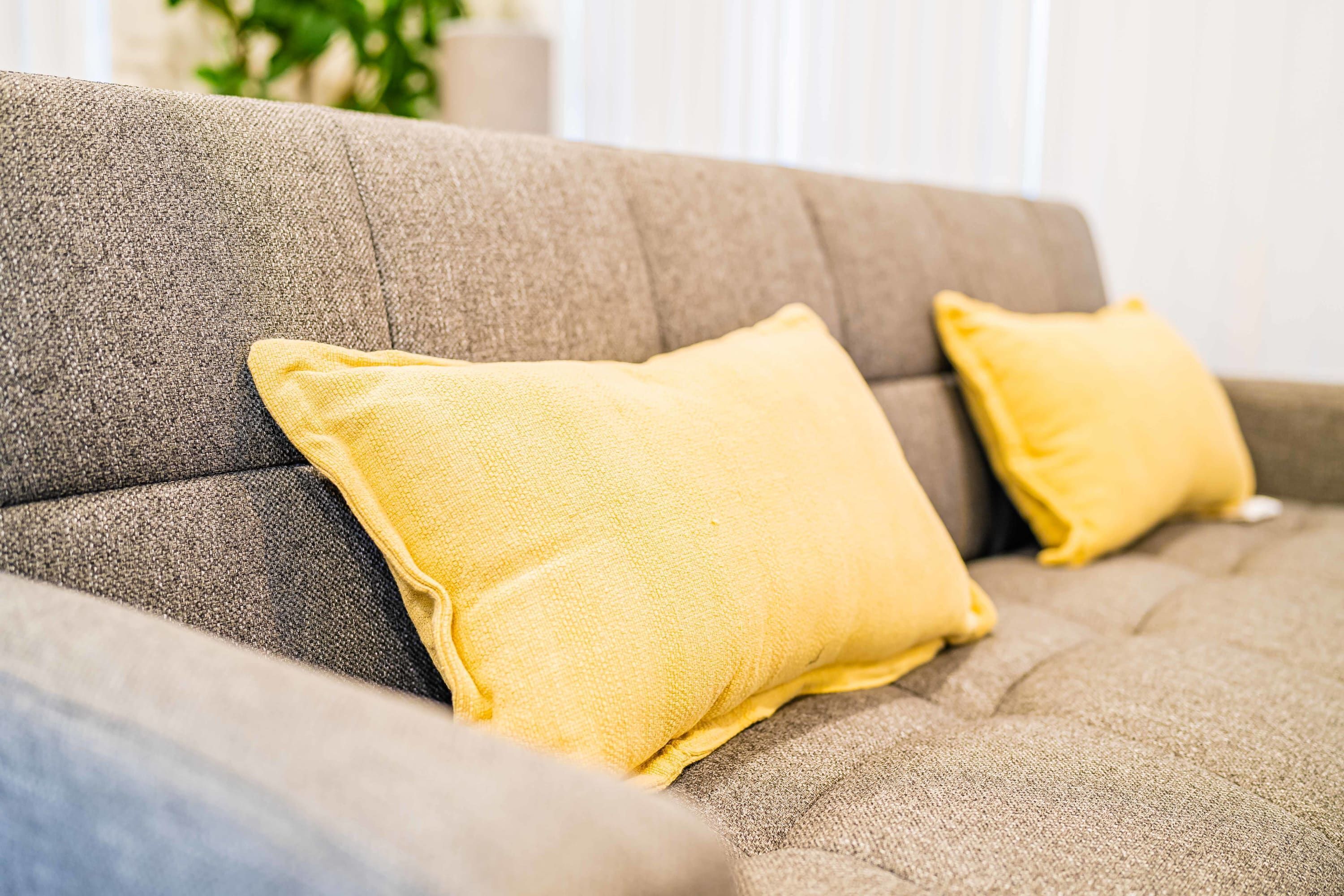 Ein Sofa mit zwei gelben Kissen.