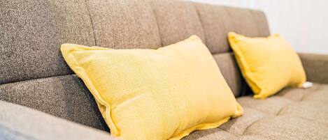 Ein Sofa mit zwei gelben Kissen.