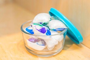 A glass container with a teal lid filled with white and purple items, possibly food or snacks, on a wooden surface. - Elegant Comfort on Historic Route 66 Attractions (Glendora)