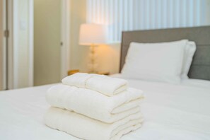A neatly made bed with a stack of white towels on the bed. - Newly Remodeled 2b2b APT Near Pasadena Old Town (Altadena)