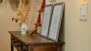 Une chambre à coucher comprenant un lit, une table de chevet, une commode, un miroir et une étagère murale agrémentée d’objets décoratifs.