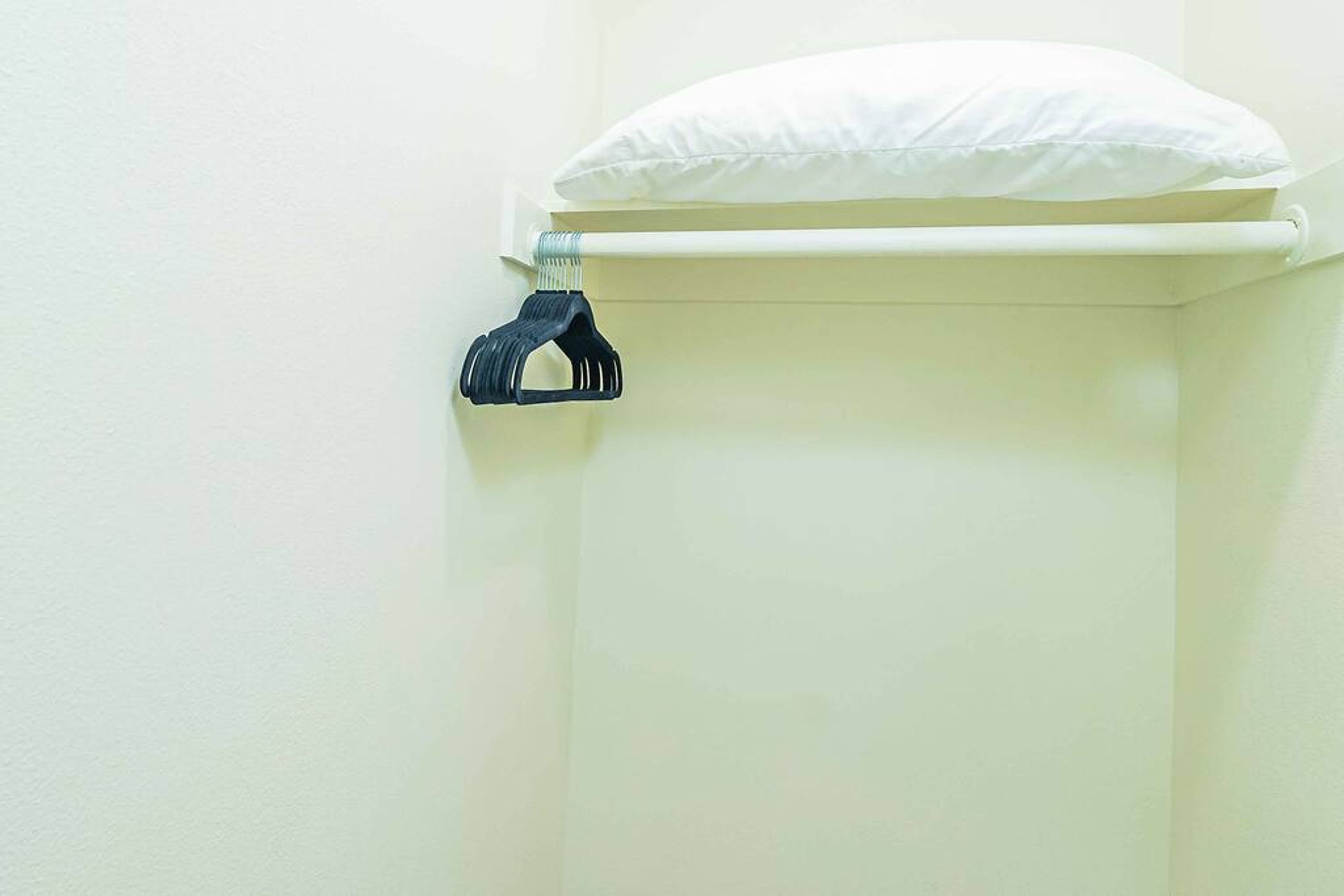 Valkoinen wc-istuin ja sen päällä valkoinen pehmuste.