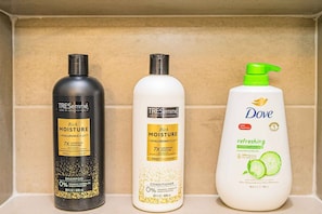 Tre flaconi di prodotti per la cura dei capelli su uno scaffale.