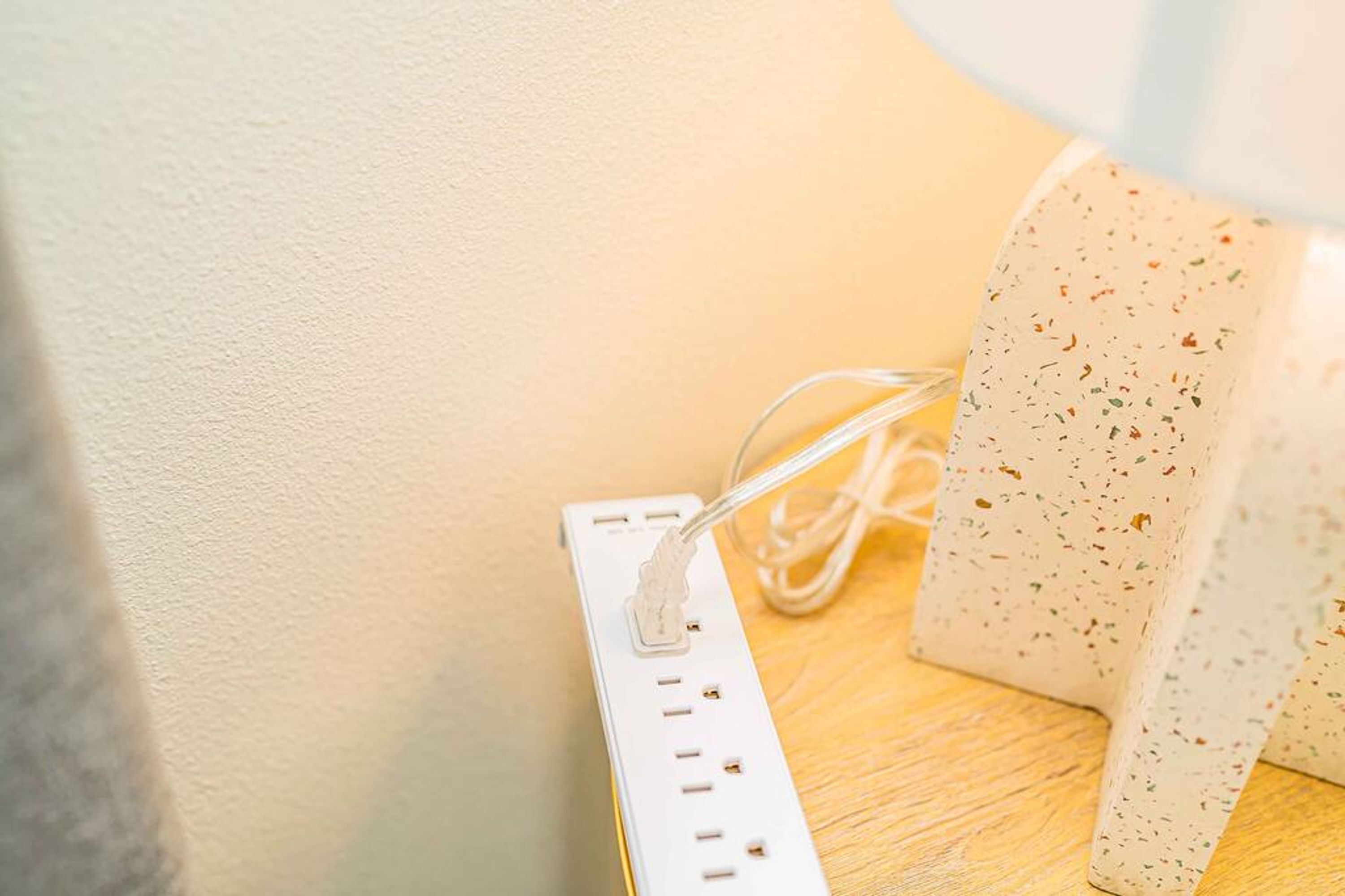 Eine weiße Mehrfachsteckdose mit mehreren Steckplätzen und einem USB-Anschluss, verbunden mit einem weißen Kabel.