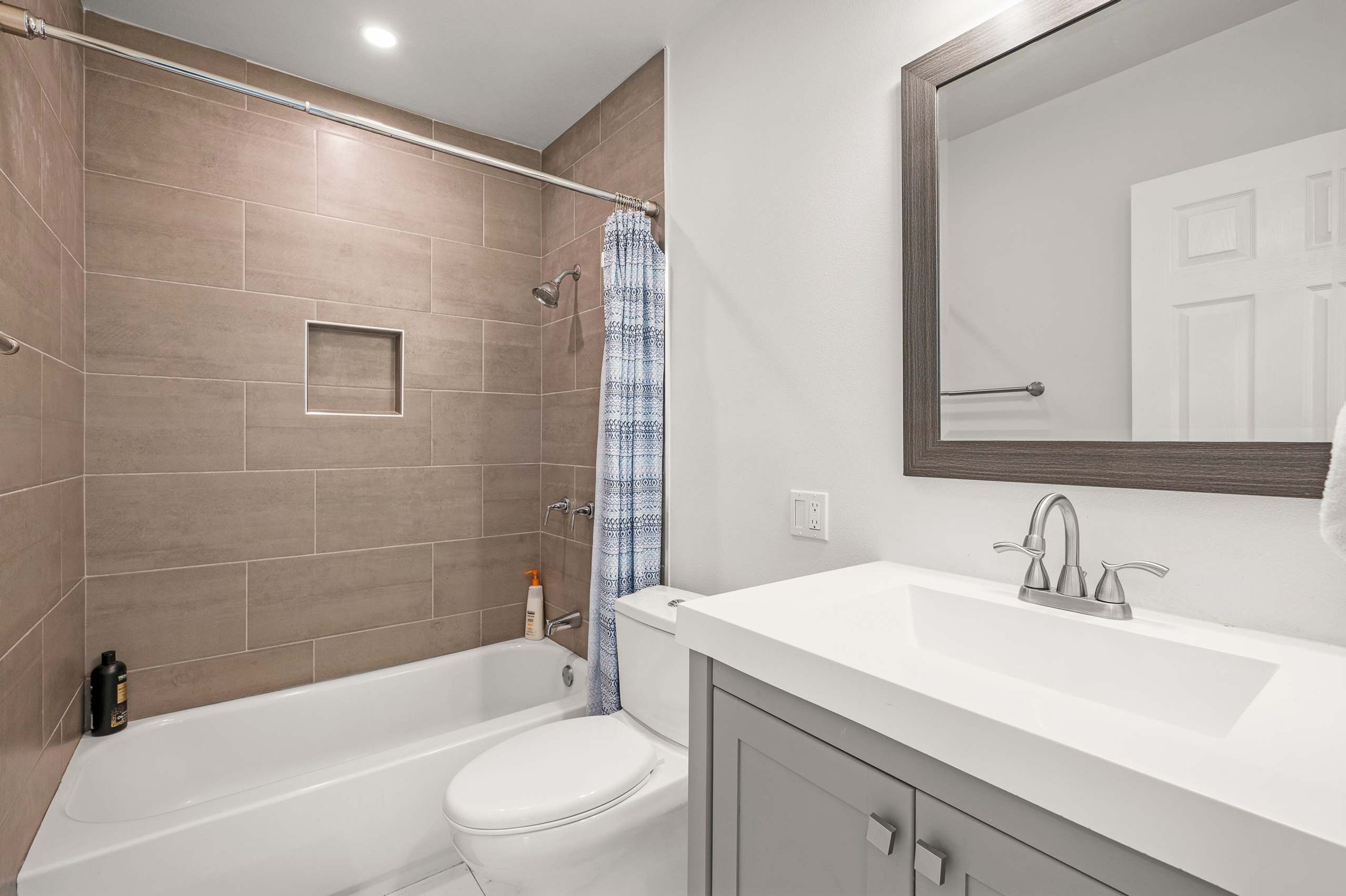 A modern bathroom with a bathtub, toilet, and sink.