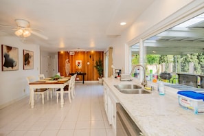 A modern kitchen with a dining area, large windows, and a ceiling fan. - Serene Retreat With Modern Comforts in San Gabriel (Rowland Heights)